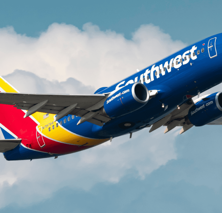 a blue and yellow airplane in the sky