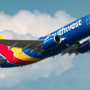 a blue and yellow airplane in the sky