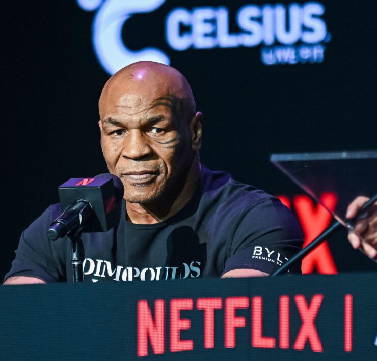 a man sitting at a podium with a microphone