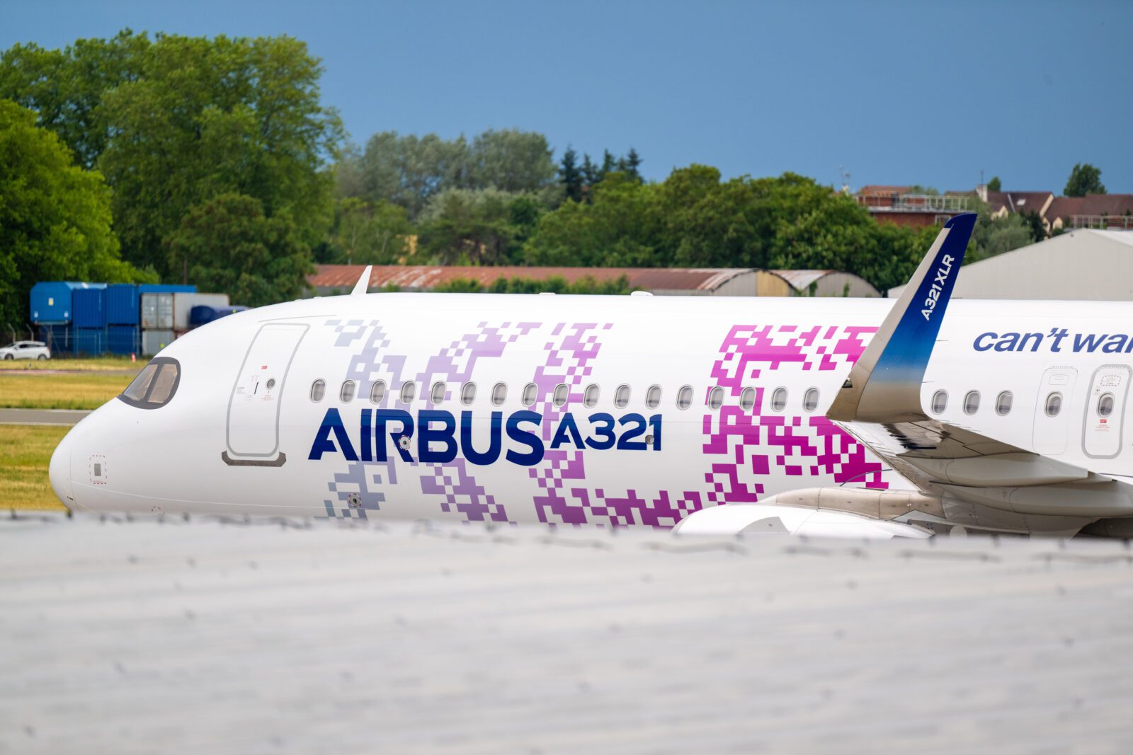 a white airplane with purple and blue writing on it