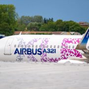 a white airplane with purple and blue writing on it