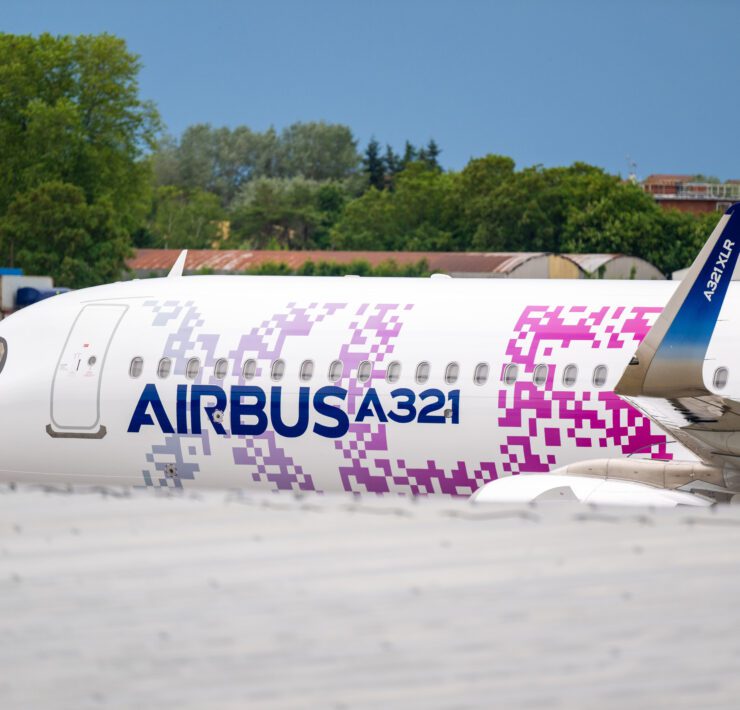 a white airplane with purple and blue writing on it