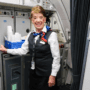 a woman in a uniform standing in a room with a door open