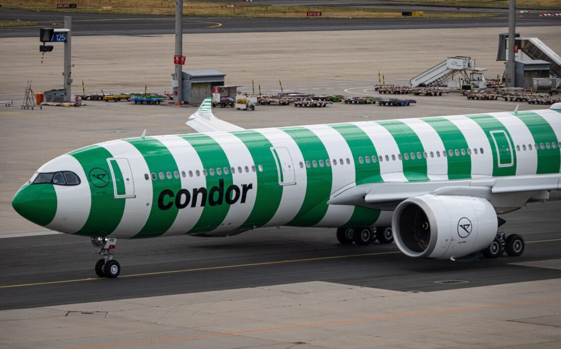 a green and white airplane on a runway
