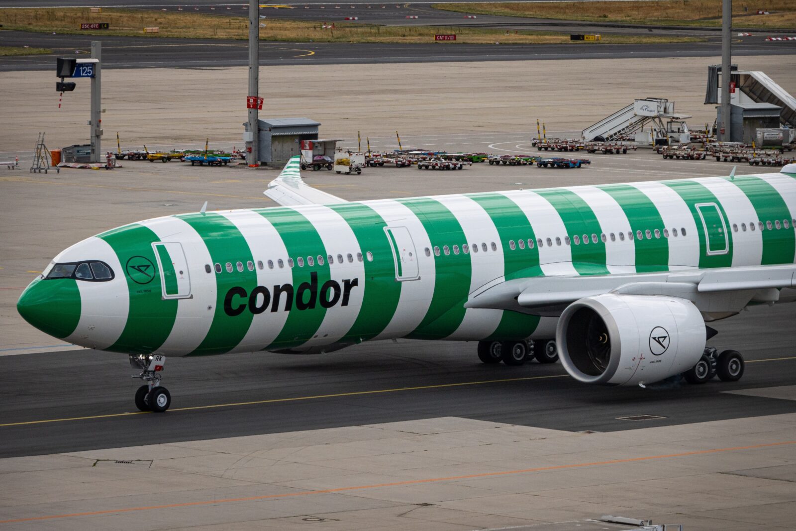 a green and white airplane on a runway