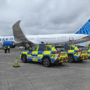 a group of police cars parked in front of an airplane