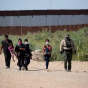 a group of people walking on a dirt road with masks