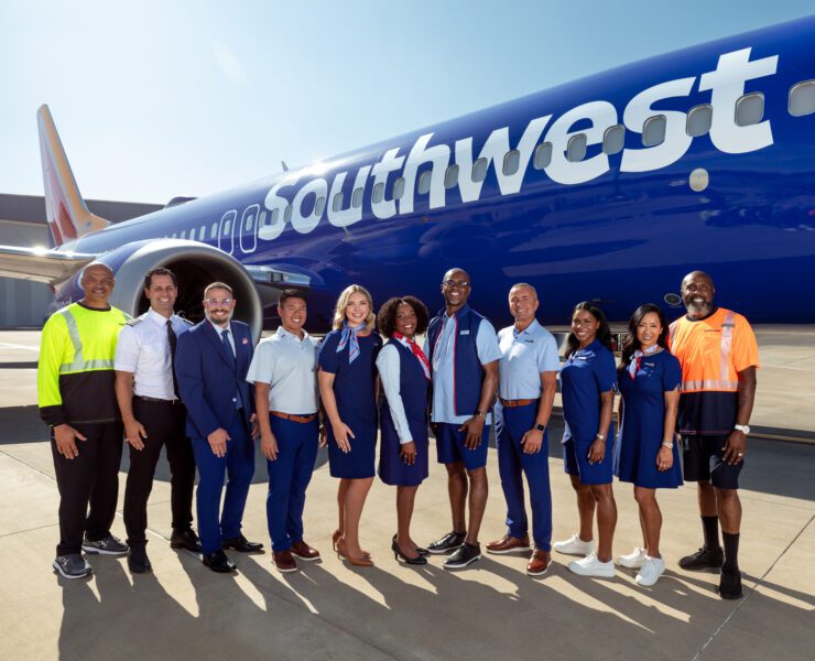 a group of people standing in front of a plane