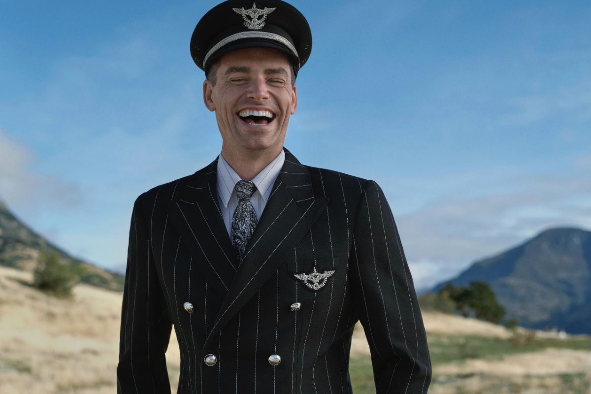 a man in a suit and hat laughing