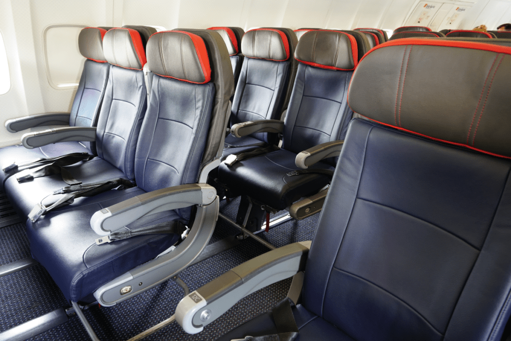 The interior of an American Airlines airplane showing several rows of Economy Class seats