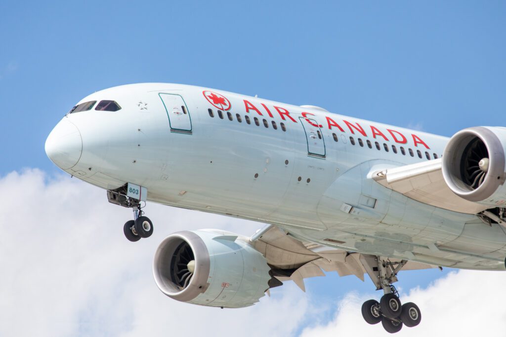 A close up of an Air Canada Boeing 787 Dreamliner flying in the sky