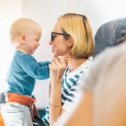 a woman holding a baby on an airplane with an extension seatbelt around the infant
