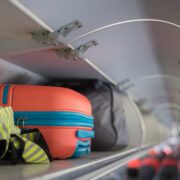 hand luggage in an overhead bin in the passenger cabin of an airplane
