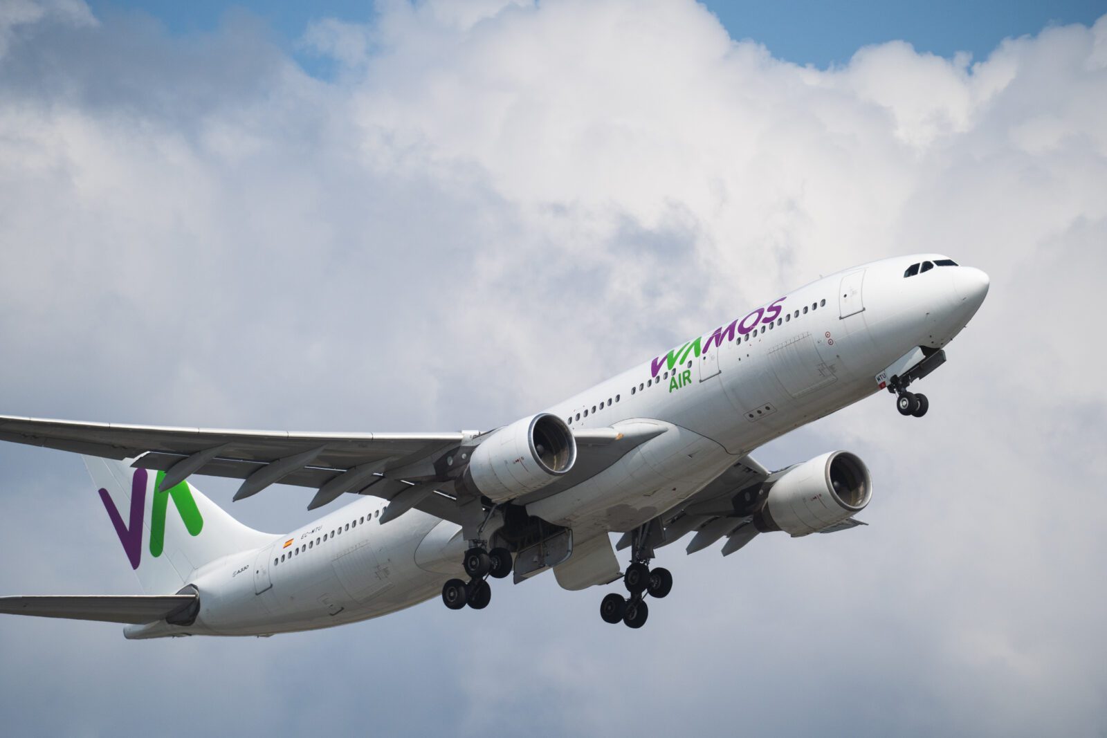 A Wamos Air Airbus A330 flying through clouds