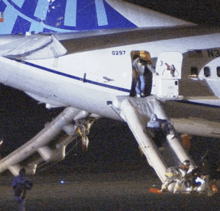Screenshot of news channel showing passenger using emergency slides to evacuate a United Airlines Boeing 737