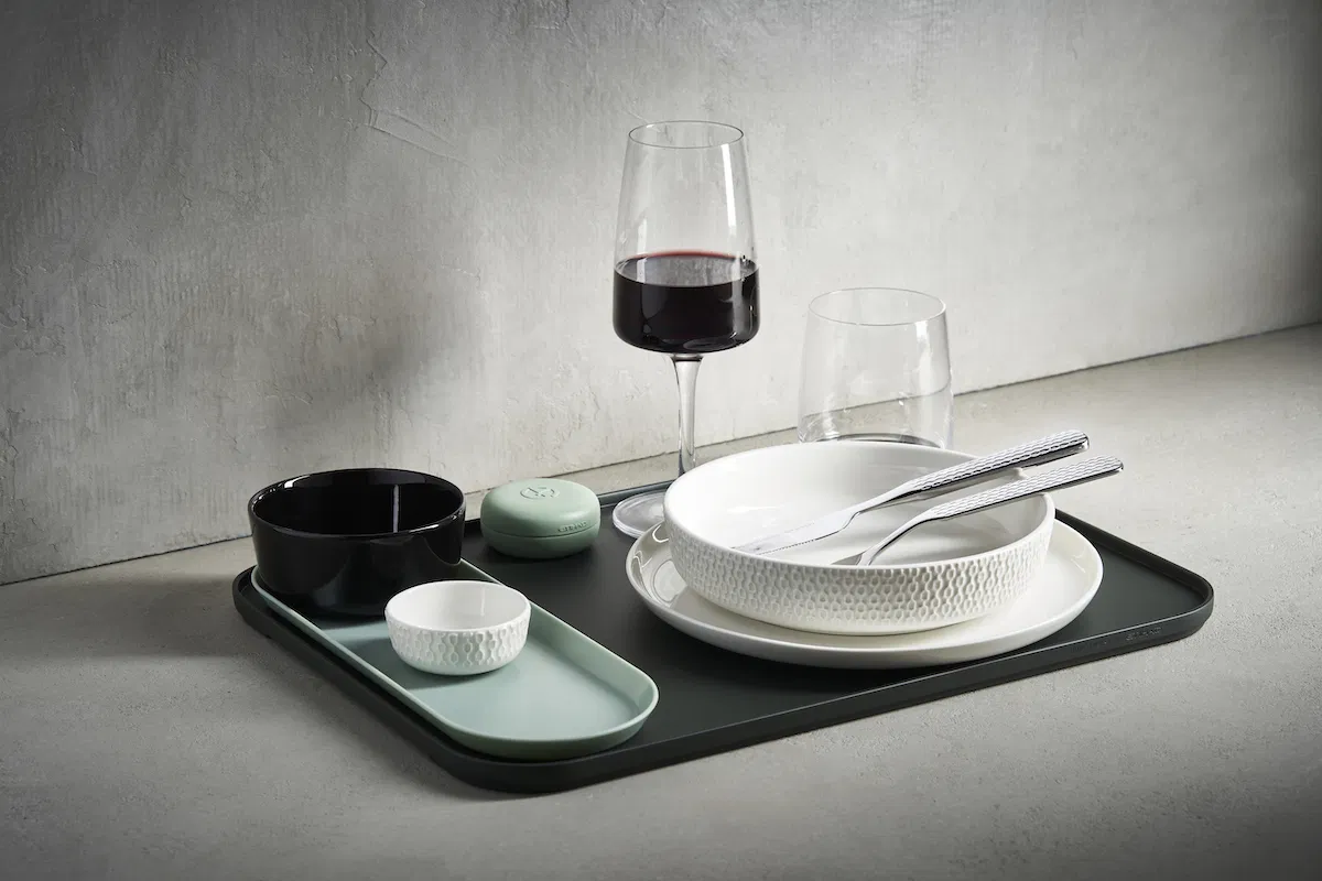 a tray with a glass of wine and a plate with utensils