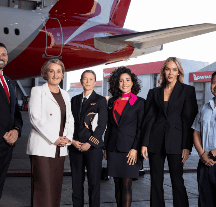 Australian designer Rebecca Vallance stands amongst a group of Qantas employees