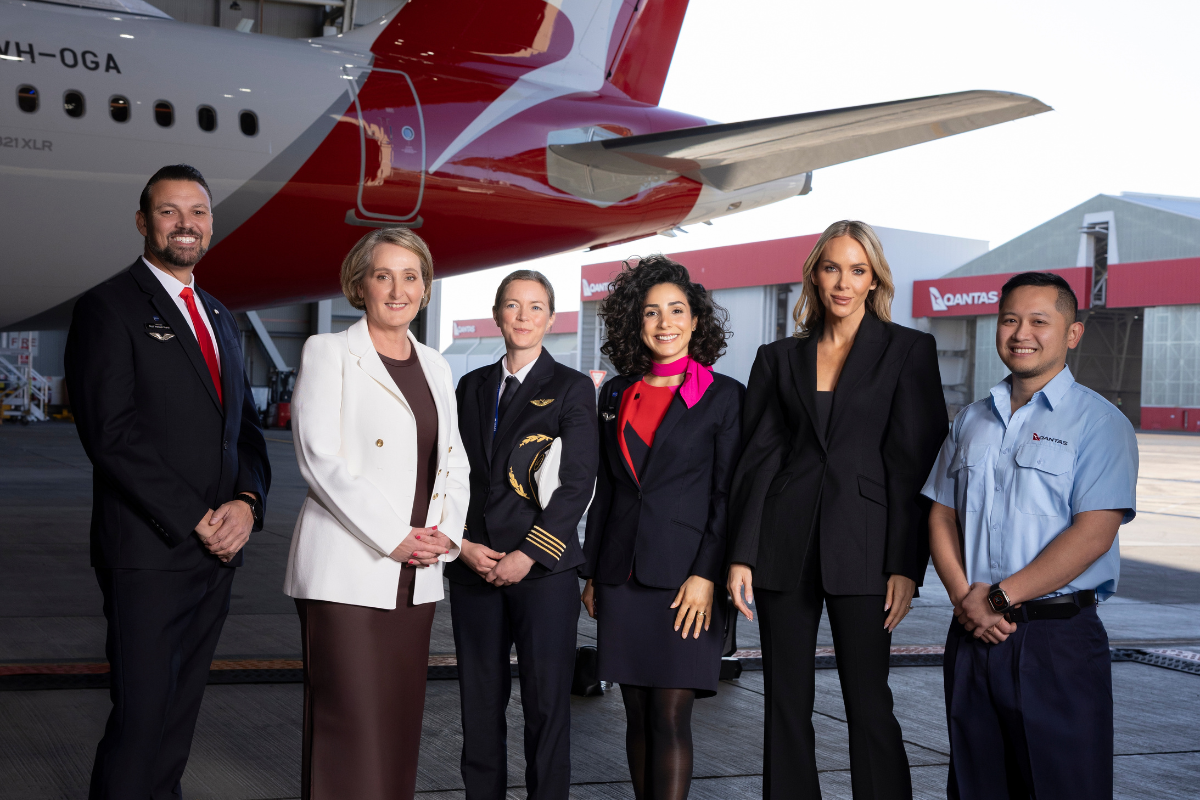 Australian designer Rebecca Vallance stands amongst a group of Qantas employees