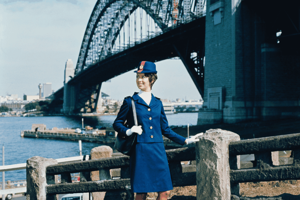 a woman in a blue uniform standing by a bridge