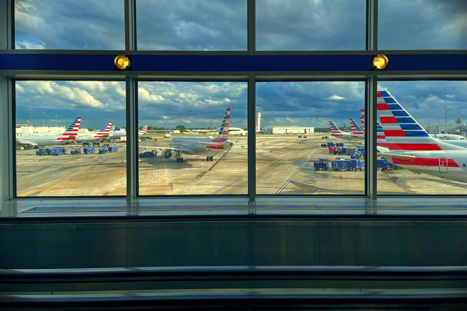 a group of american airlines planes on the tarmac at Charlotte Airport, as seen through a window in the terminal
