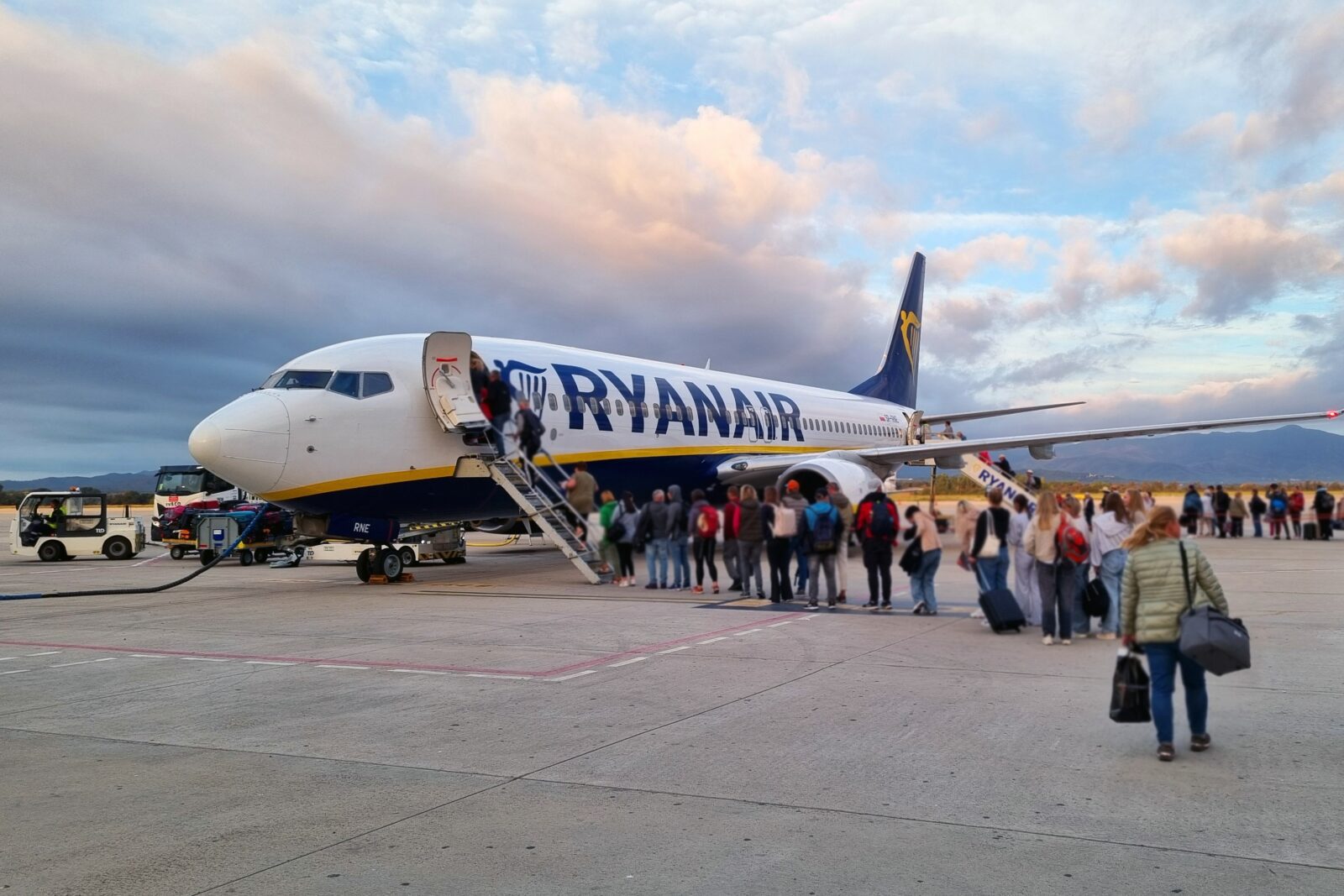 passengers lining up to board a ryanair boeing 737 parked on the apron