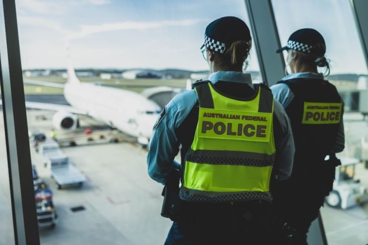 a police officers looking out a window at an airplane