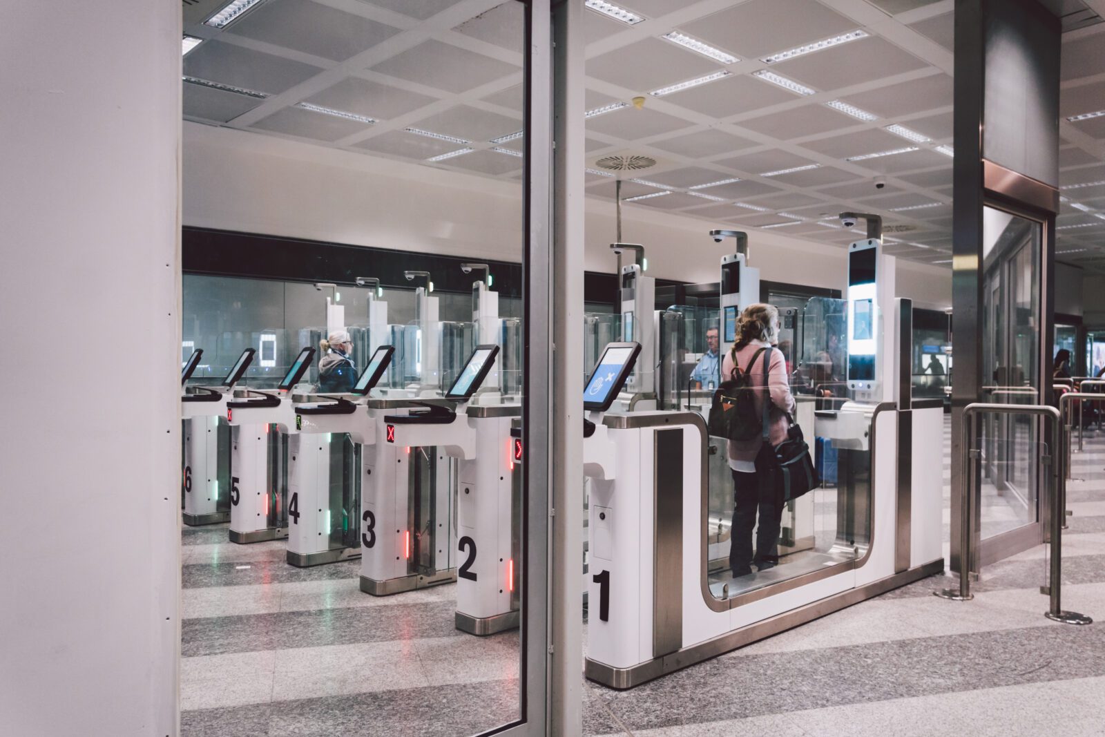 a woman passing through an automated passport gate in Milan