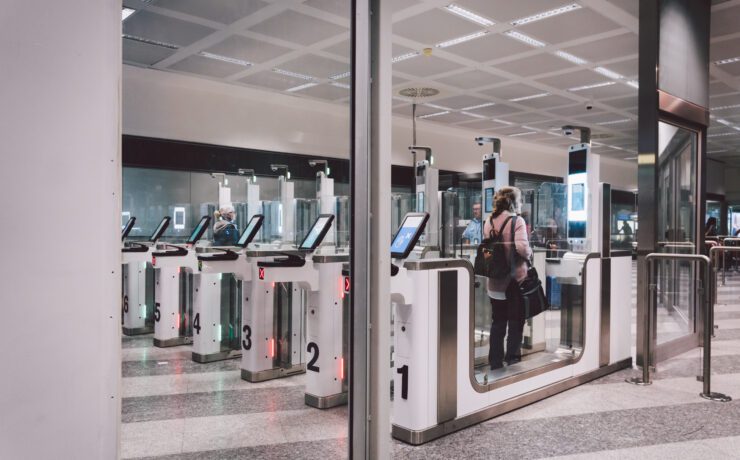 a woman passing through an automated passport gate in Milan