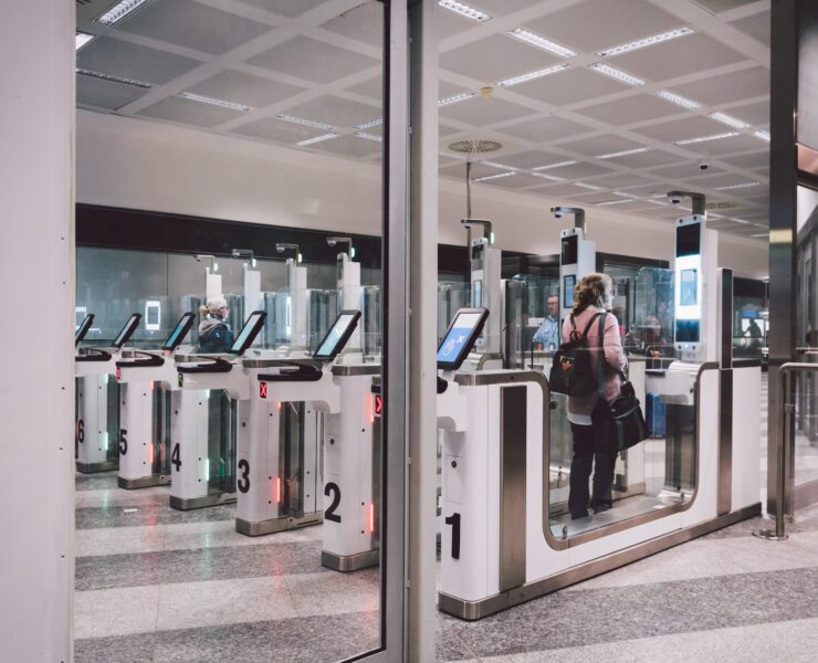 a woman passing through an automated passport gate in Milan