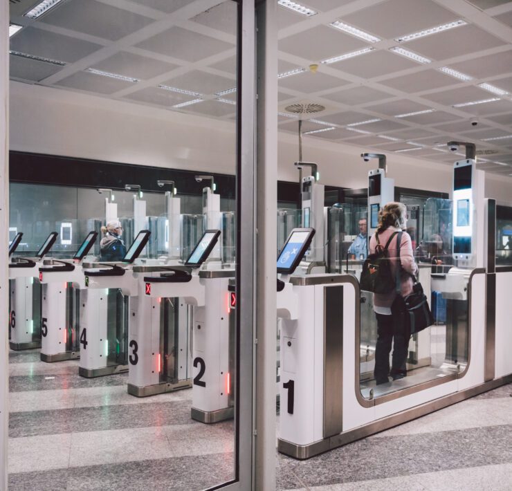 a woman passing through an automated passport gate in Milan