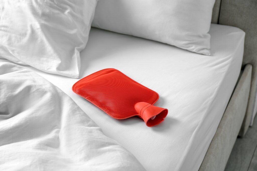 a red hot water bottle on a bed