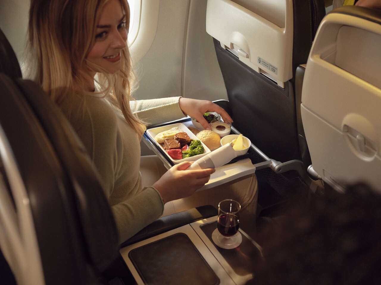 a woman sitting in an airplane eating food