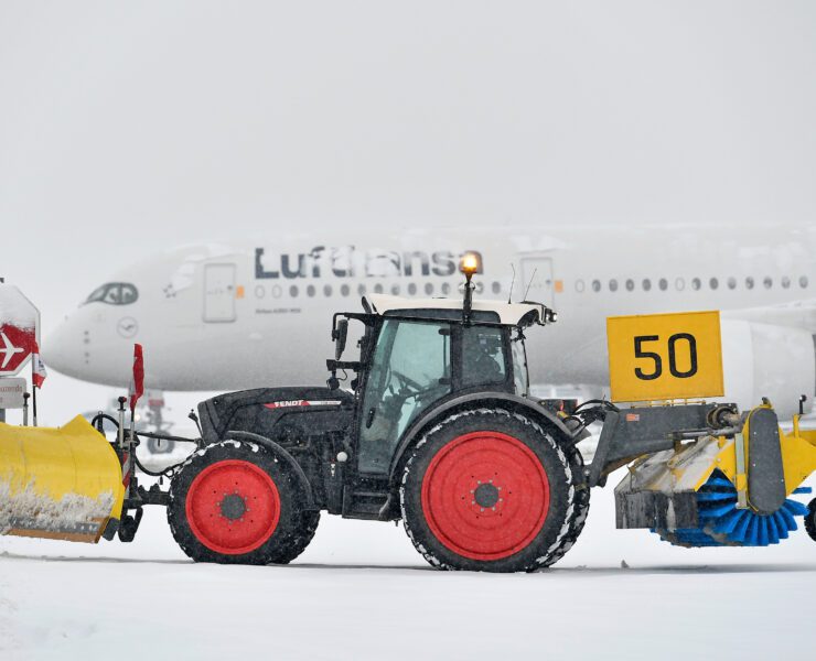 heavy snowfall at munich airport with a lufthansa plane covered in snow
