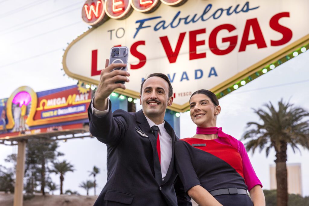 a man and woman taking a selfie in front of a sign