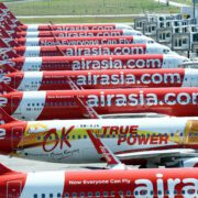 AIRASIA planes lined up...a row of airplanes with white text on them