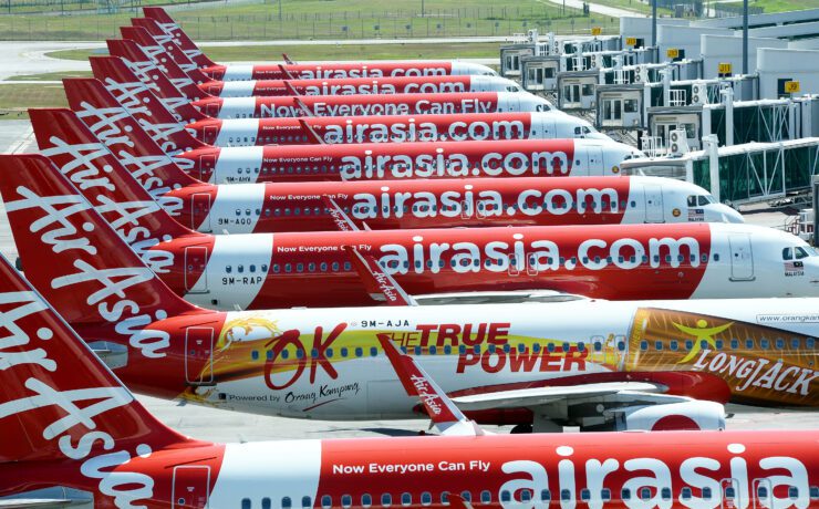 AIRASIA planes lined up...a row of airplanes with white text on them