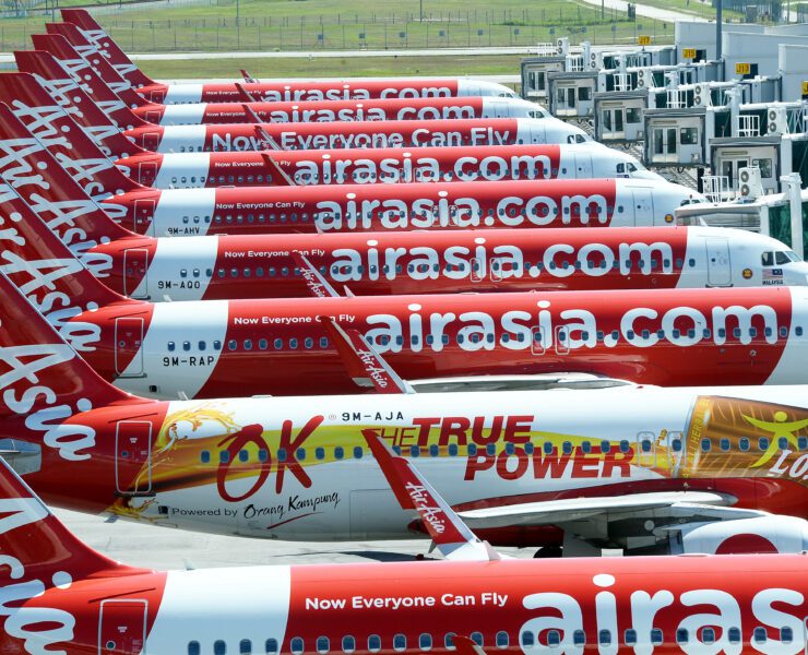 AIRASIA planes lined up...a row of airplanes with white text on them