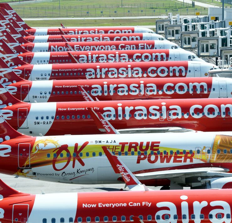 AIRASIA planes lined up...a row of airplanes with white text on them