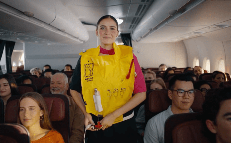 a woman in a yellow life vest standing in a plane