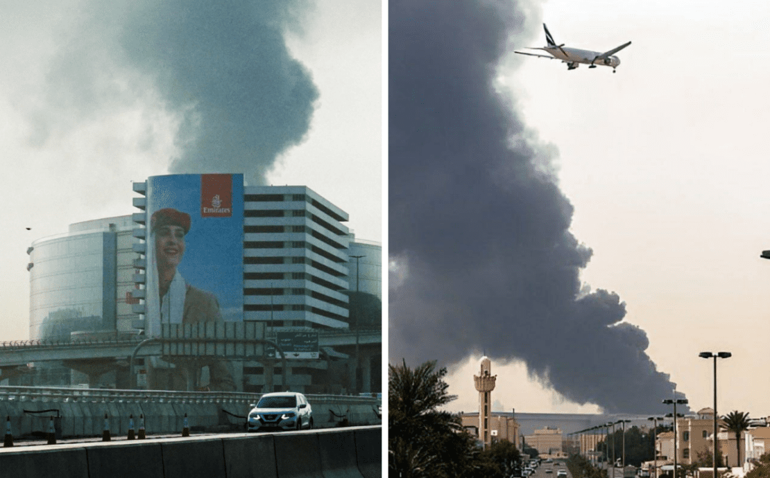 a plane flying over a building with smoke coming out of it