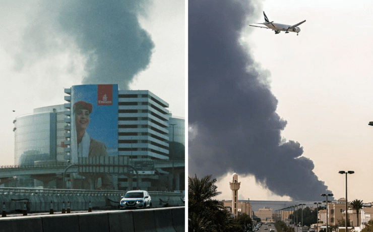 a plane flying over a building with smoke coming out of it