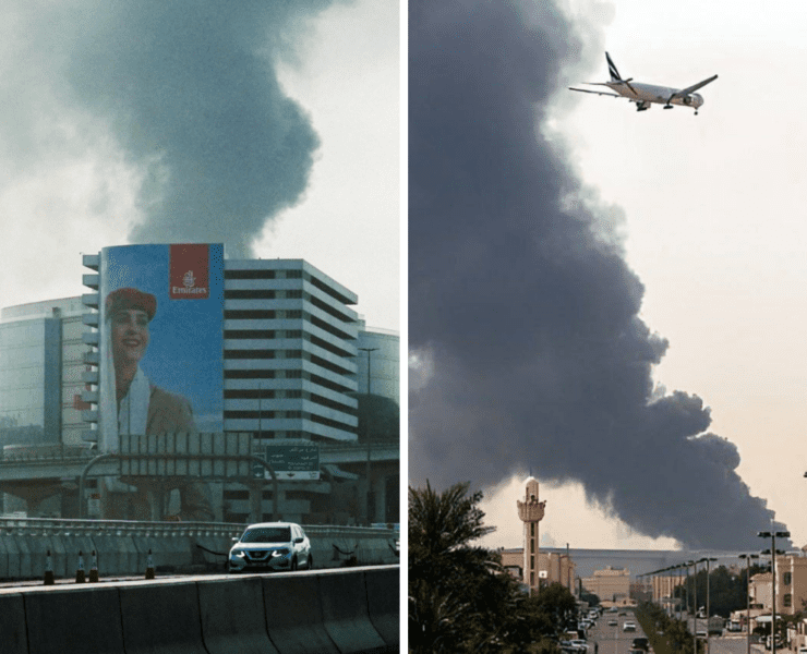 a plane flying over a building with smoke coming out of it
