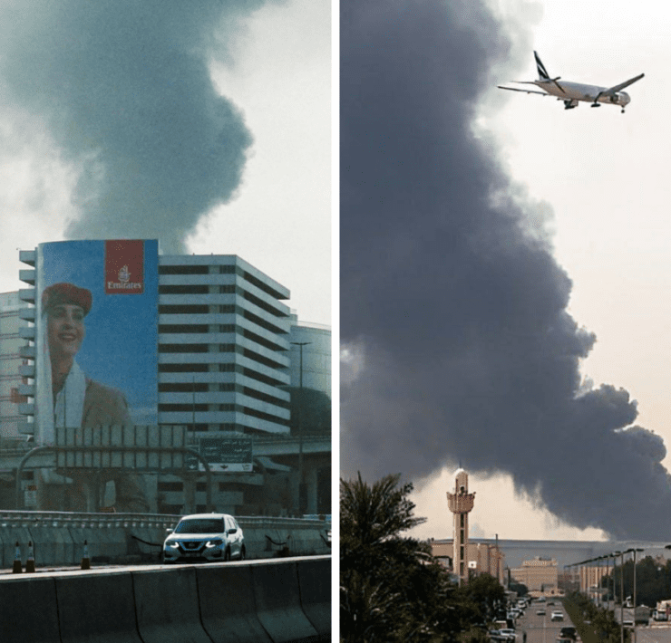 a plane flying over a building with smoke coming out of it