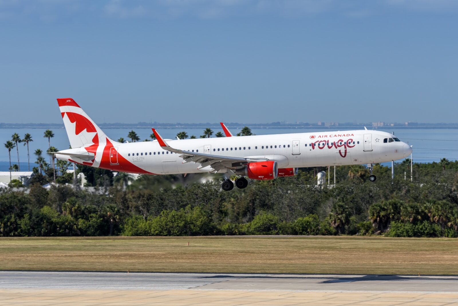 an air canada rouge plane coming into land at tampa airport a plane taking off from a runway