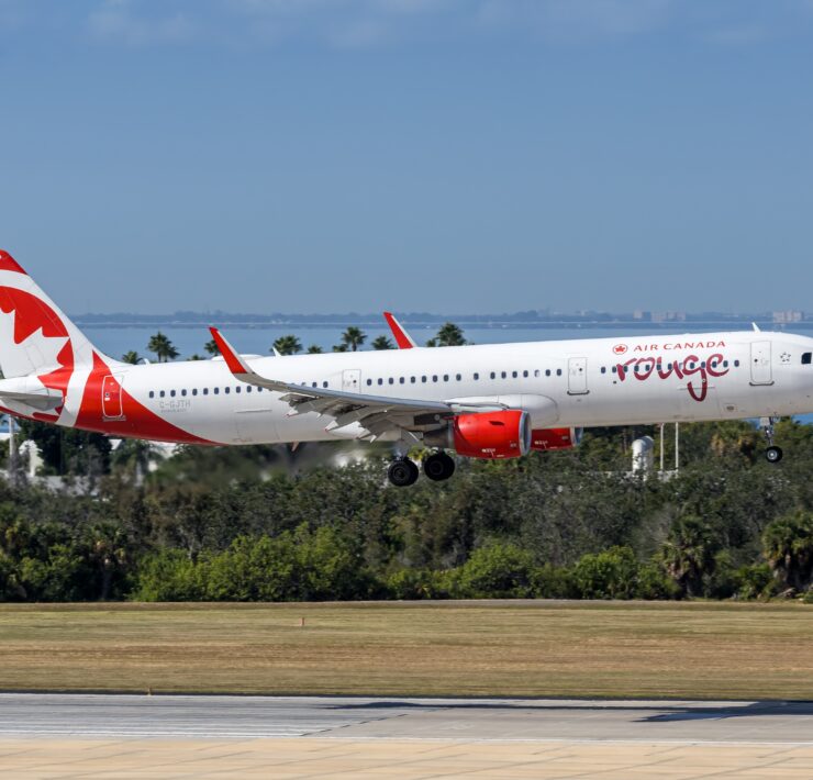 an air canada rouge plane coming into land at tampa airport a plane taking off from a runway