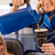 An Alaska Airlines flight attendant poring coffee