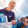 a delta air lines flight attendant performing a beverage service in the cabin