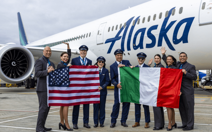 flight crew holding flags in front of an alaska airlines boeing 787