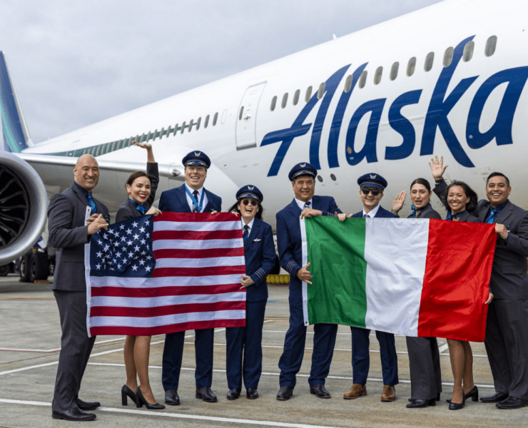 flight crew holding flags in front of an alaska airlines boeing 787