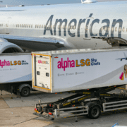 two catering trucks at the side of an American Airlines aircraft